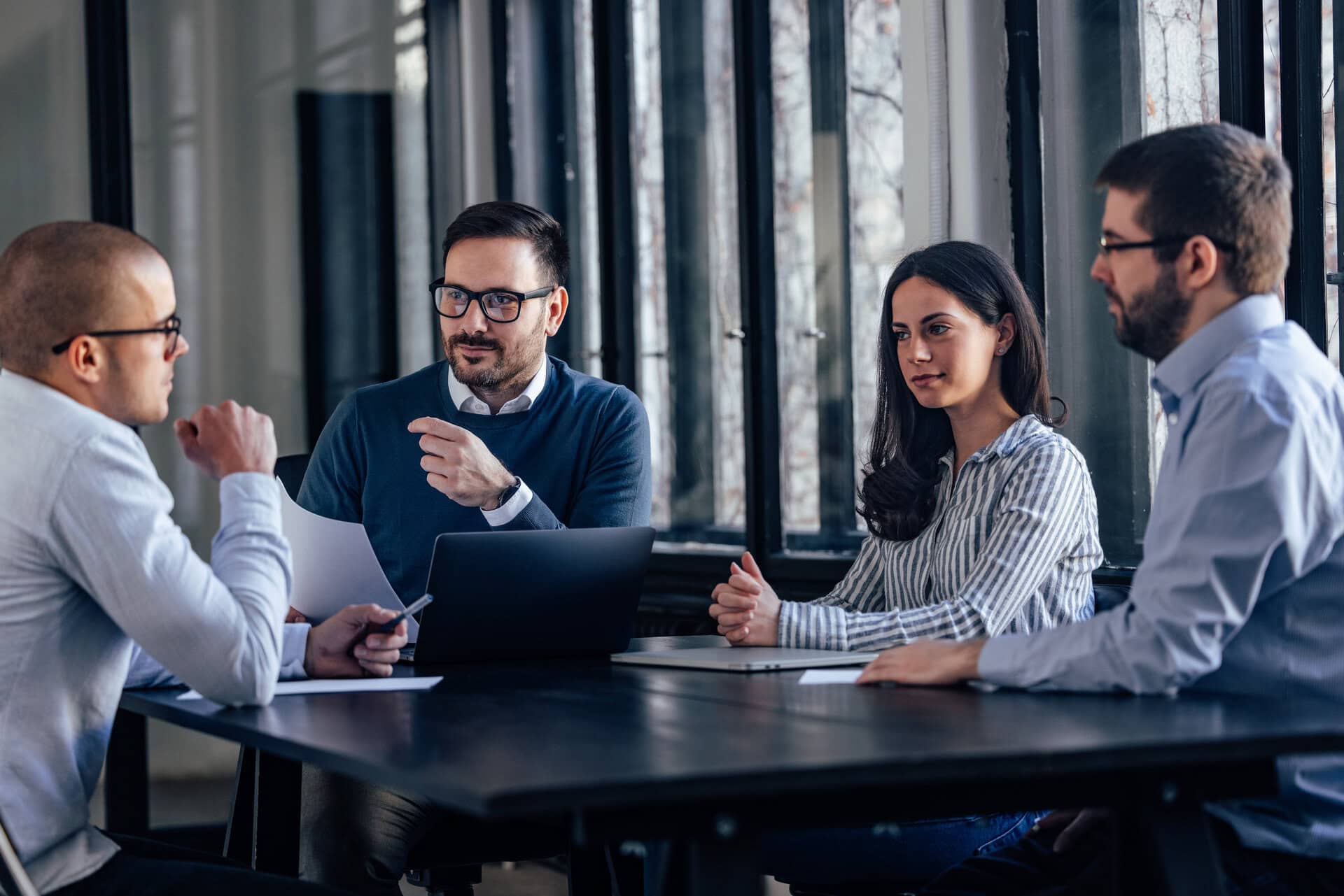 Business professionals collaborating during a meeting in a contemporary office environment.
